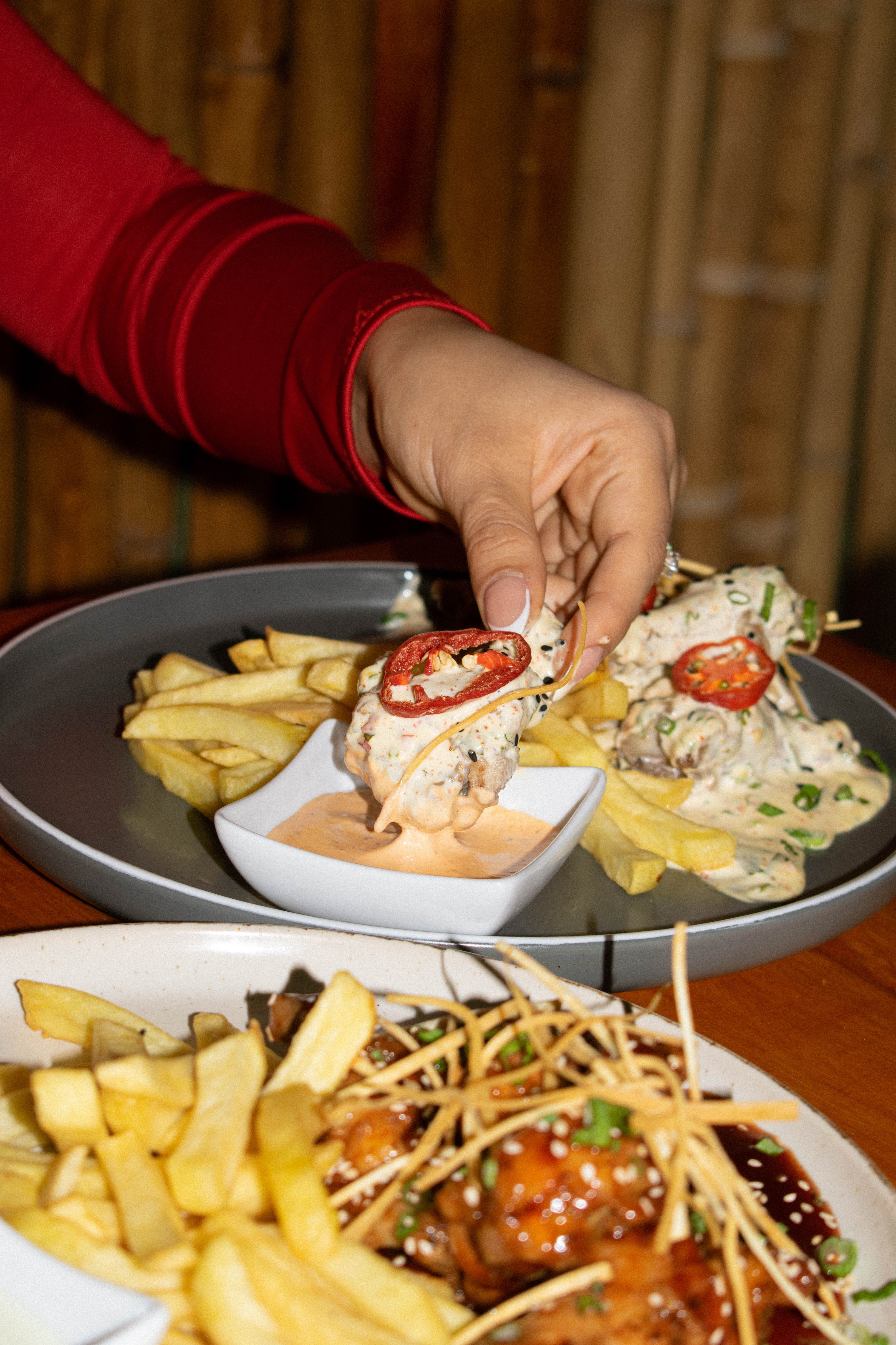 A diner reaching for a fresh plate of food at a restaurant